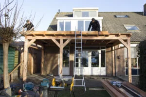 Timmerlieden bouwen een veranda aan het huis in de achtertuin