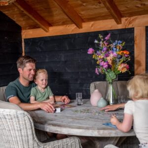 Douglas veranda met gezin aan tafel die spelletje doen