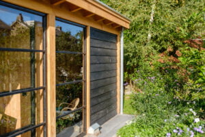 Tuinkamer met glazen wand met zwart hout